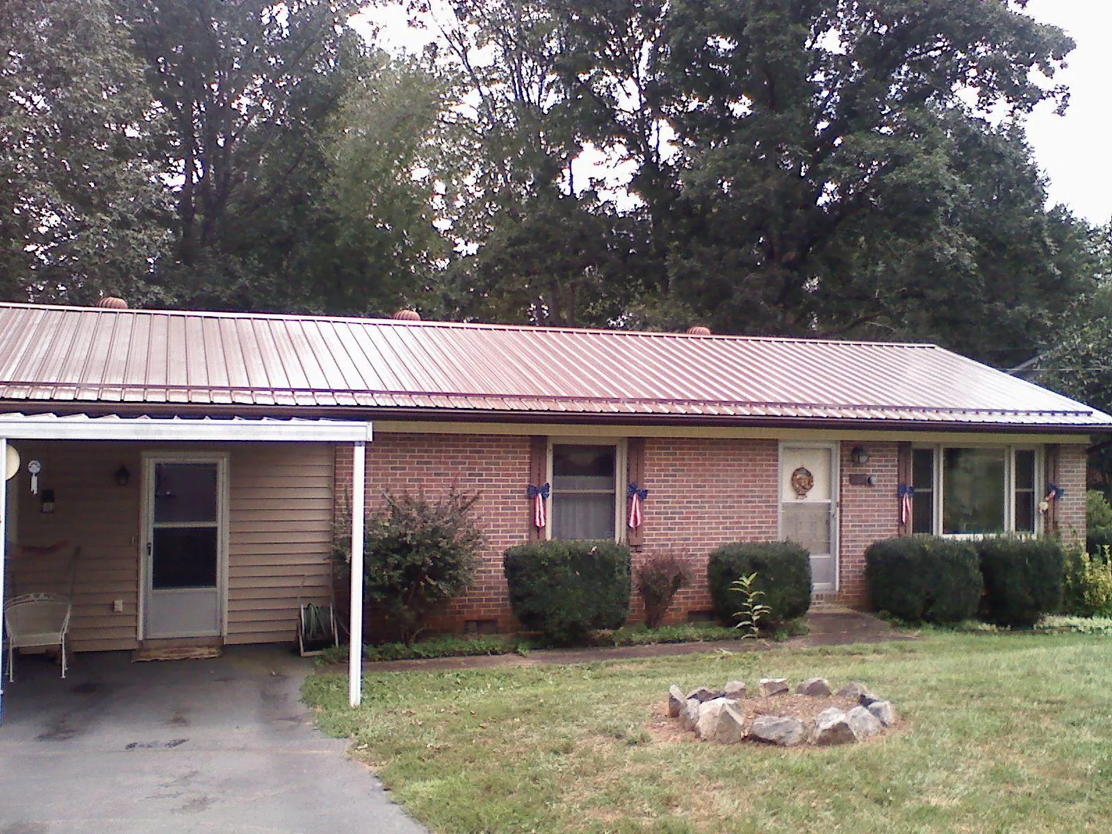 Bronze metal roof and carport on a brick ranch home — Roof Repair work by our crew in Alexis