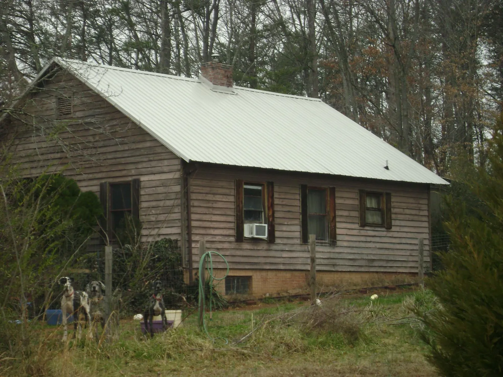 White metal roof on an old wood sided farmhouse, from a Metal Roof Installation job in Alexis